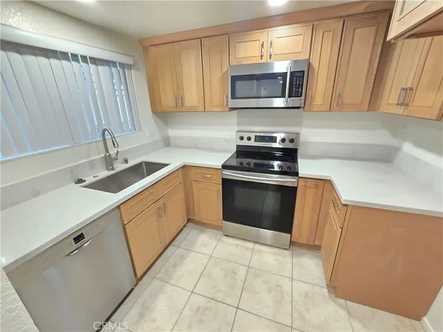 a kitchen with stainless steel appliances granite countertop a sink stove and microwave
