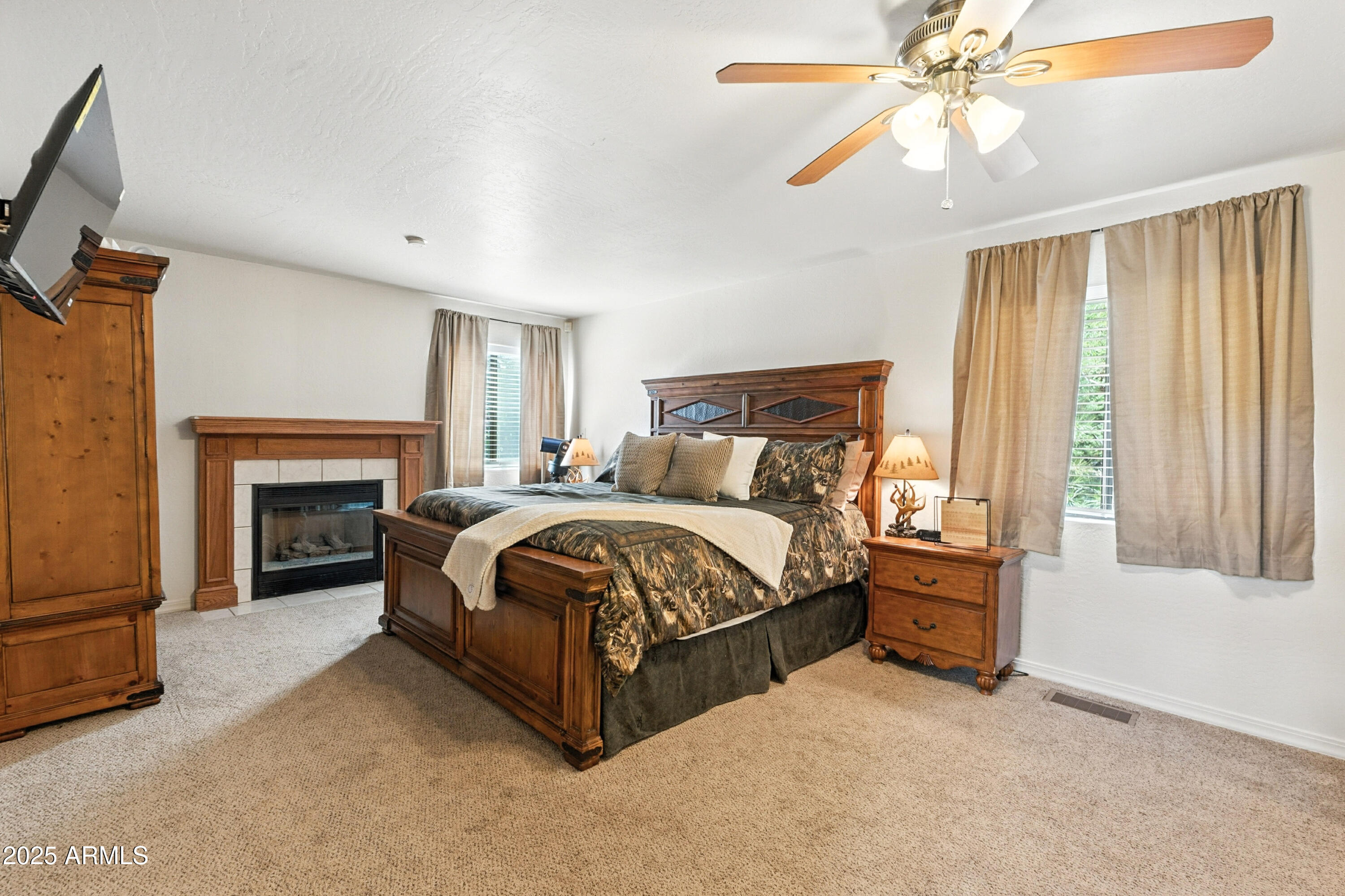 199 South Greystone Circle Payson, AZ 85541 - Photo 25 of 83 a spacious bedroom with a bed and a fireplace