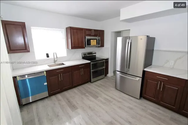 a kitchen with stainless steel appliances granite countertop a refrigerator stove and sink