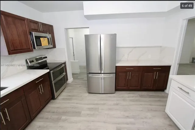 a kitchen with stainless steel appliances a refrigerator and wooden cabinets