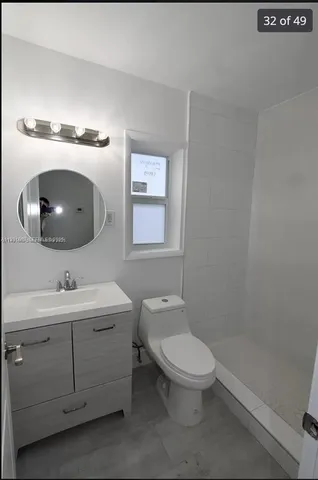 a bathroom with a toilet a sink and mirror