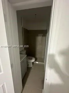 a white toilet sitting next to a shower