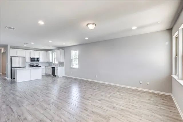 a view of a kitchen with a sink and wooden floor