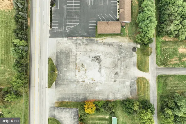 an aerial view of residential houses with outdoor space and trees