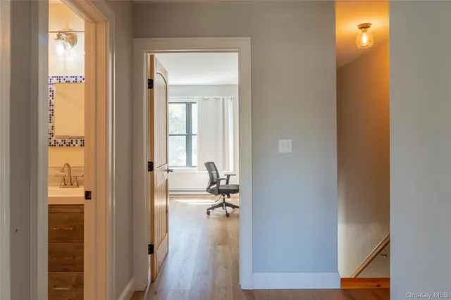 a view of a hallway with a room wooden floor and closet