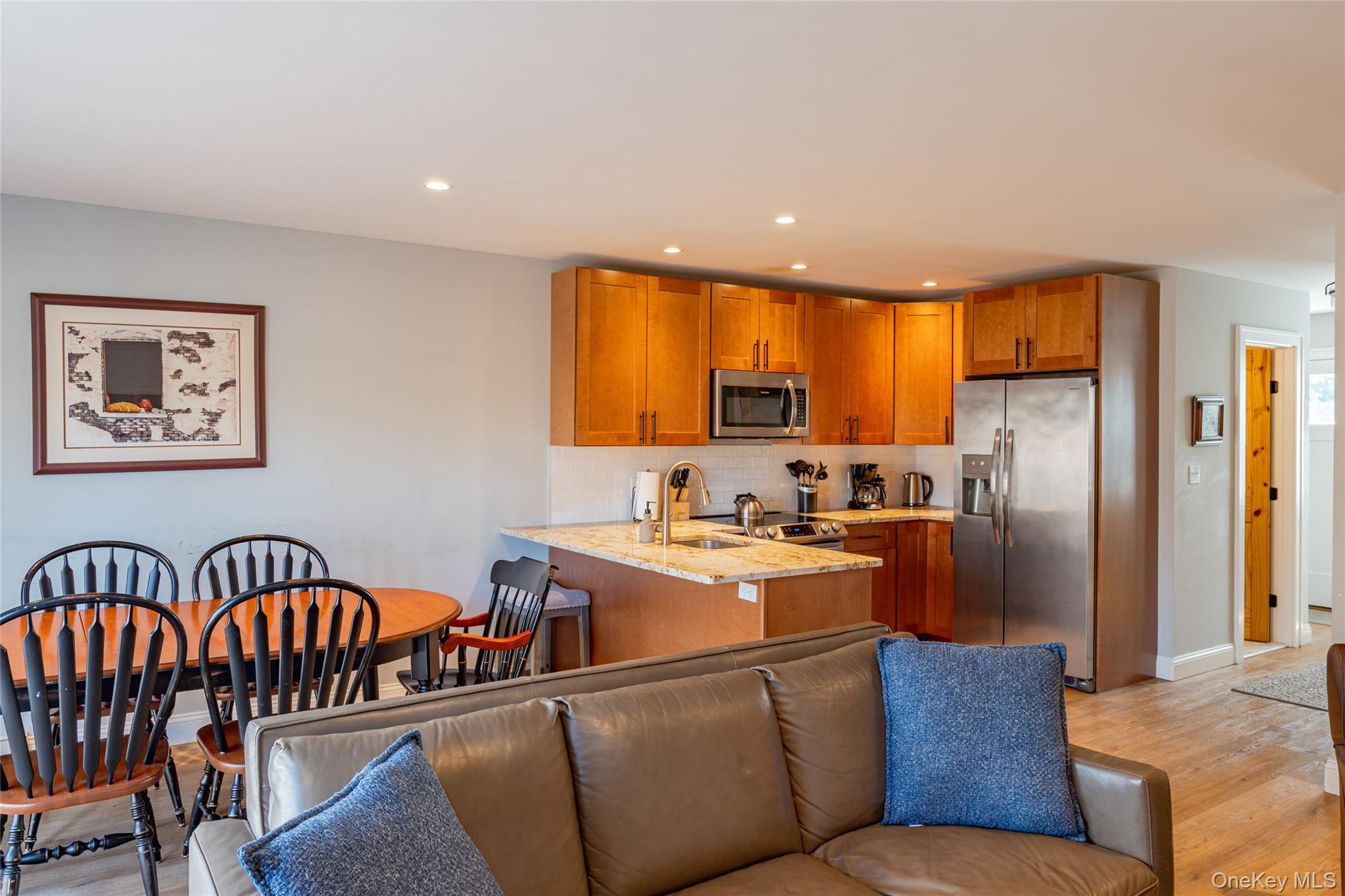 71 County Road 65, Unit 6 Windham, NY 12439 - Photo 9 of 38 a kitchen with stainless steel appliances granite countertop a refrigerator a stove a sink dishwasher a dining table and chairs with wooden floor
