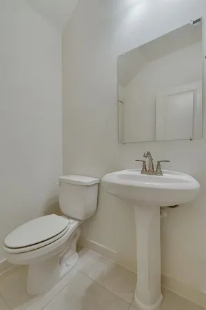 a bathroom with a sink a toilet and mirror