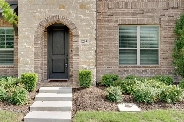 a front view of a house with potted plants