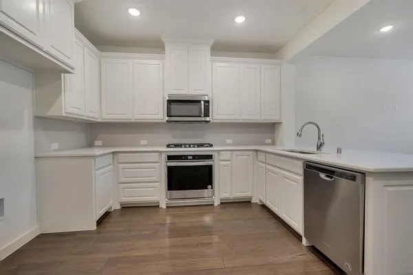 a kitchen with granite countertop a sink stove and cabinets