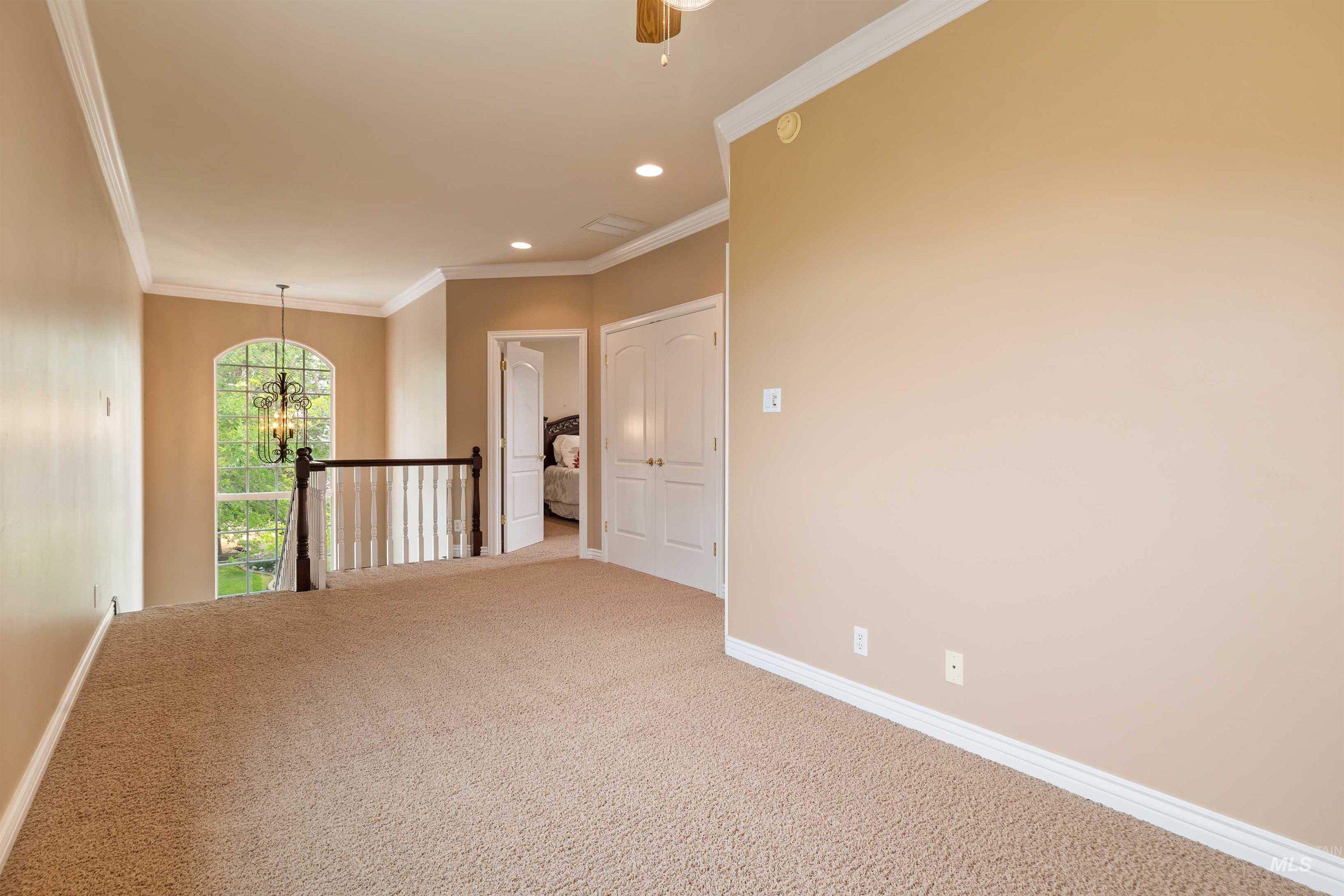 3404 Ridge Line Drive Kimberly, ID 83341 - Photo 25 of 50 Carpeted loft area featuring a large arched window, white trim molding, recessed lighting, and a dark wood and white spindle railing