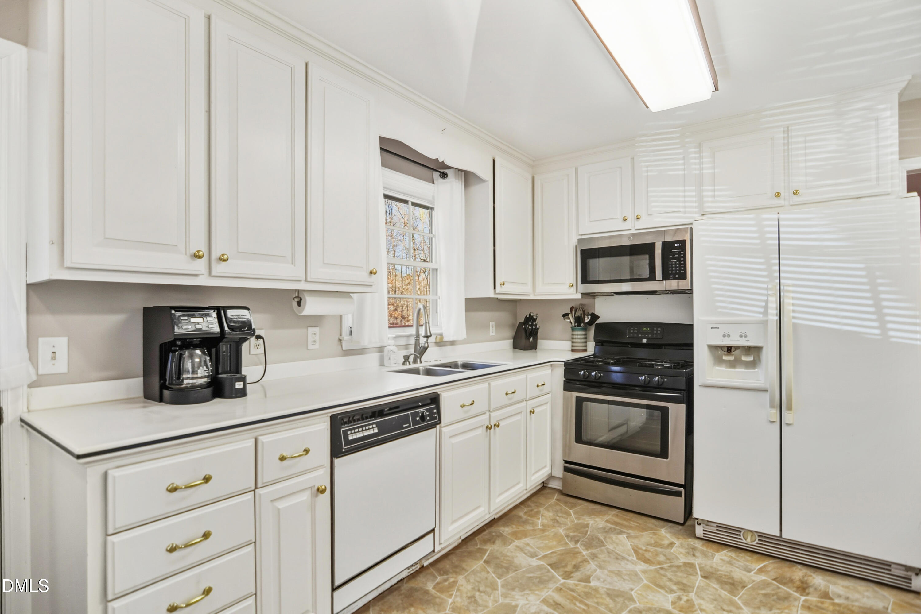 4911 Seterra Bend Durham, NC 27712 - Photo 9 of 26 a kitchen with granite countertop white cabinets stainless steel appliances and sink