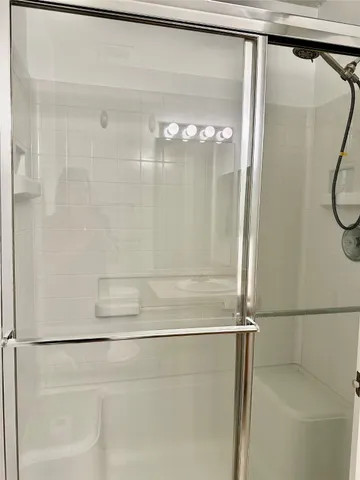 a bathroom with a glass shower door
