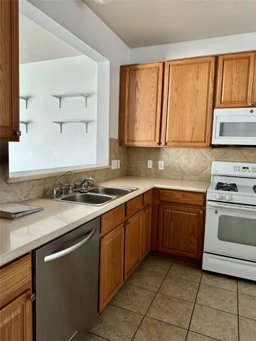a kitchen with a sink stove top oven and cabinets