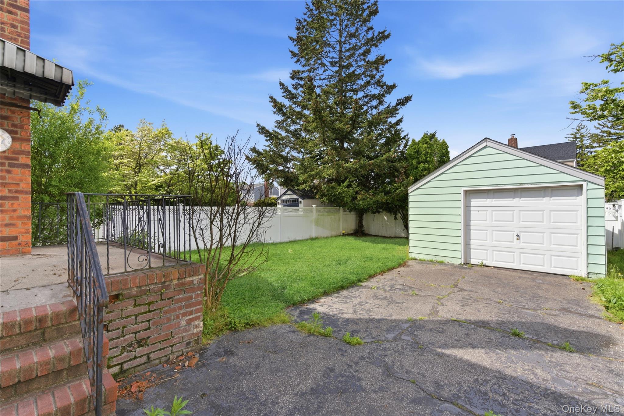 325 White Road Mineola, NY 11501 - Photo 13 of 17 a view of a house with a small yard and wooden fence