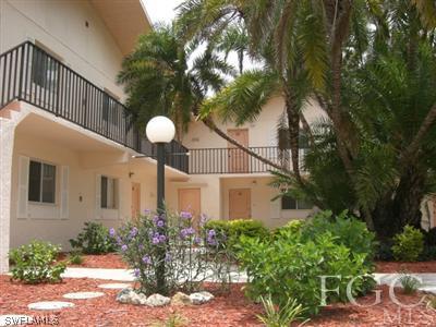 8049 Country Road, Unit 203 Fort Myers, FL 33919 - Photo 1 of 10 a front view of a house with a yard and fountain in middle