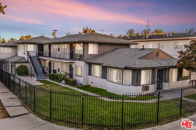 a view of a house with a yard and potted plants