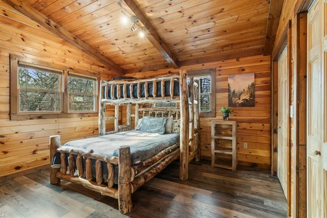 a bedroom with a bed next to a large window with the outer view