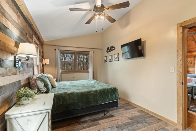 a bedroom with a bed a window and flat screen tv