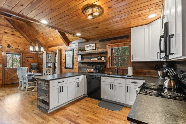 a kitchen with stainless steel appliances granite countertop a sink a stove and cabinets