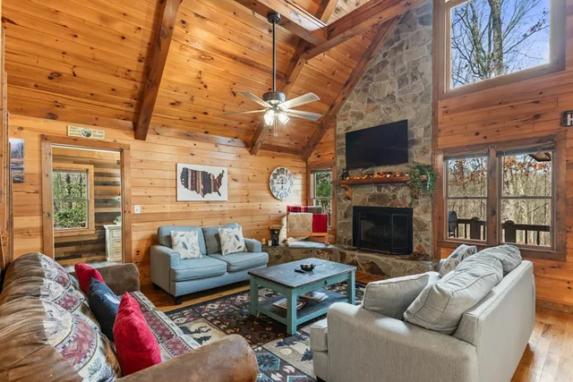 a living room with furniture a flat screen tv and a fireplace