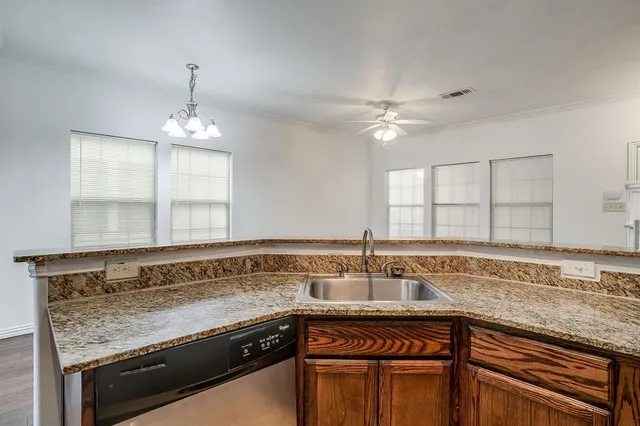 a kitchen with stainless steel appliances granite countertop a sink and dishwasher with wooden floor