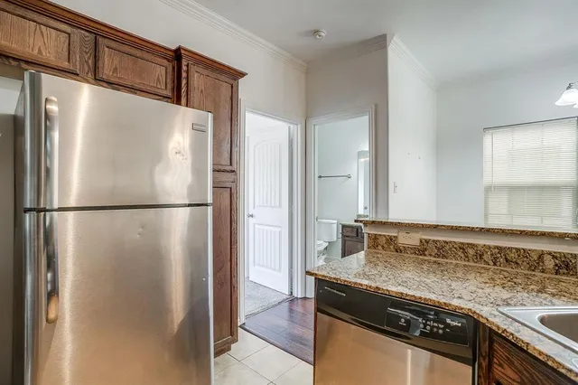 a kitchen with granite countertop a refrigerator and a sink