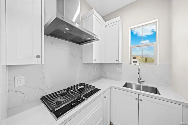 a kitchen with a stove and white cabinets