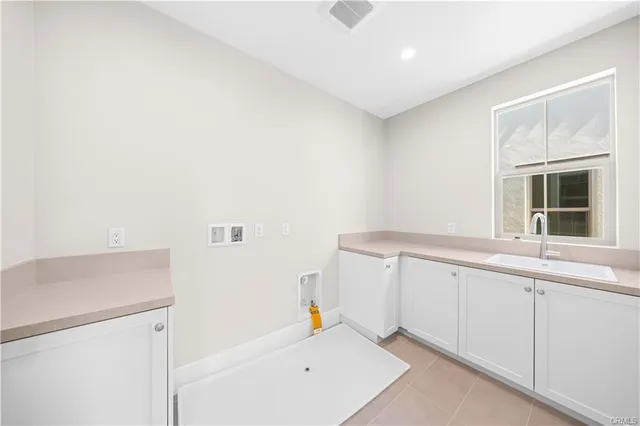a hallway with white cabinets and window