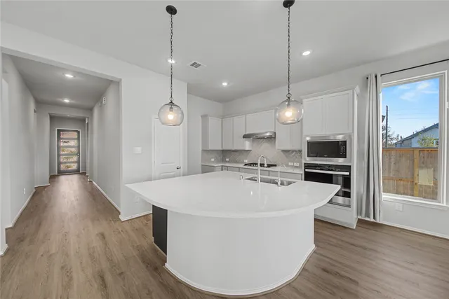 a bathroom with a granite countertop sink a mirror and shower