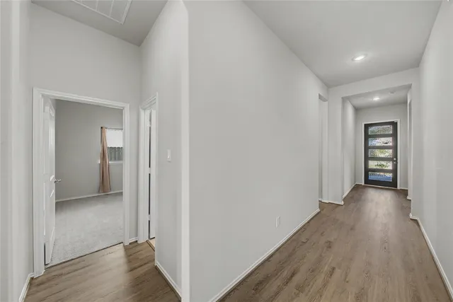 a view of a hallway with wooden floor