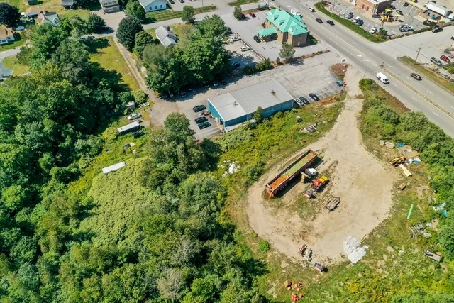 an aerial view of a house with a yard and trees