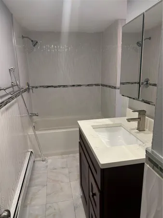 a bathroom with a sink vanity and tub