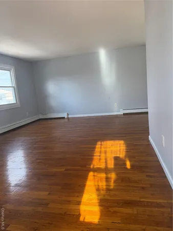 a view of empty room with wooden floor and windows