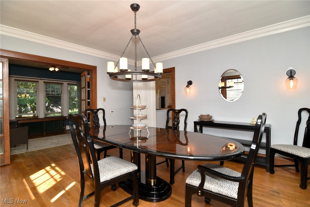 17930 Rosecliff Road Cleveland, OH 44119 - Photo 12 of 50 Dining area featuring a chandelier, wood finished floors, ornamental molding, and radiator
