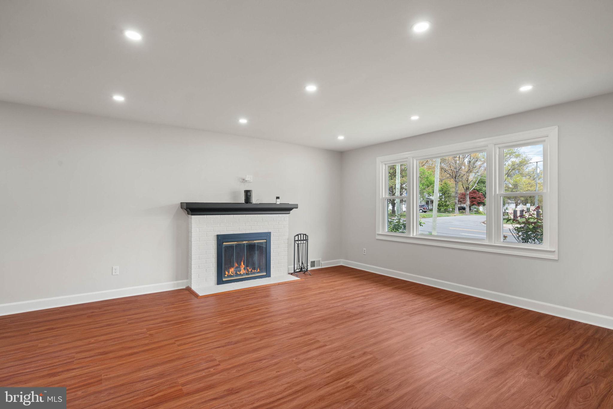 6607 Edsall Road Springfield, VA 22151 - Photo 17 of 47 an empty room with wooden floor fireplace and windows