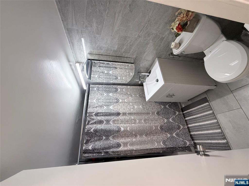 265 Main Street, Unit 113 Ridgefield Park, NJ 07660 - Photo 4 of 13 a bathroom with a sink toilet and mirror
