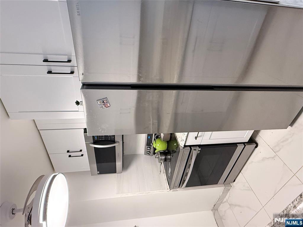 265 Main Street, Unit 113 Ridgefield Park, NJ 07660 - Photo 7 of 13 a kitchen with stainless steel appliances granite countertop a stove a microwave and a refrigerator