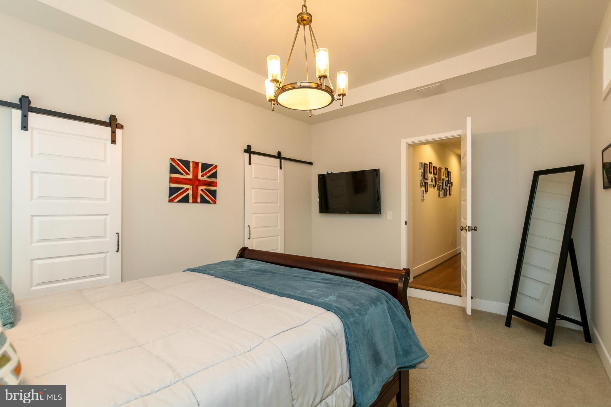 829 Kingston Road Baltimore, MD 21212 - Photo 21 of 30 a bedroom with a bed and a flat tv screen