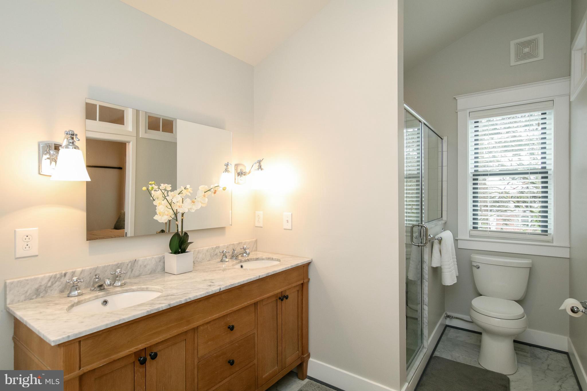 829 Kingston Road Baltimore, MD 21212 - Photo 23 of 30 a bathroom with a granite countertop toilet a sink and a mirror