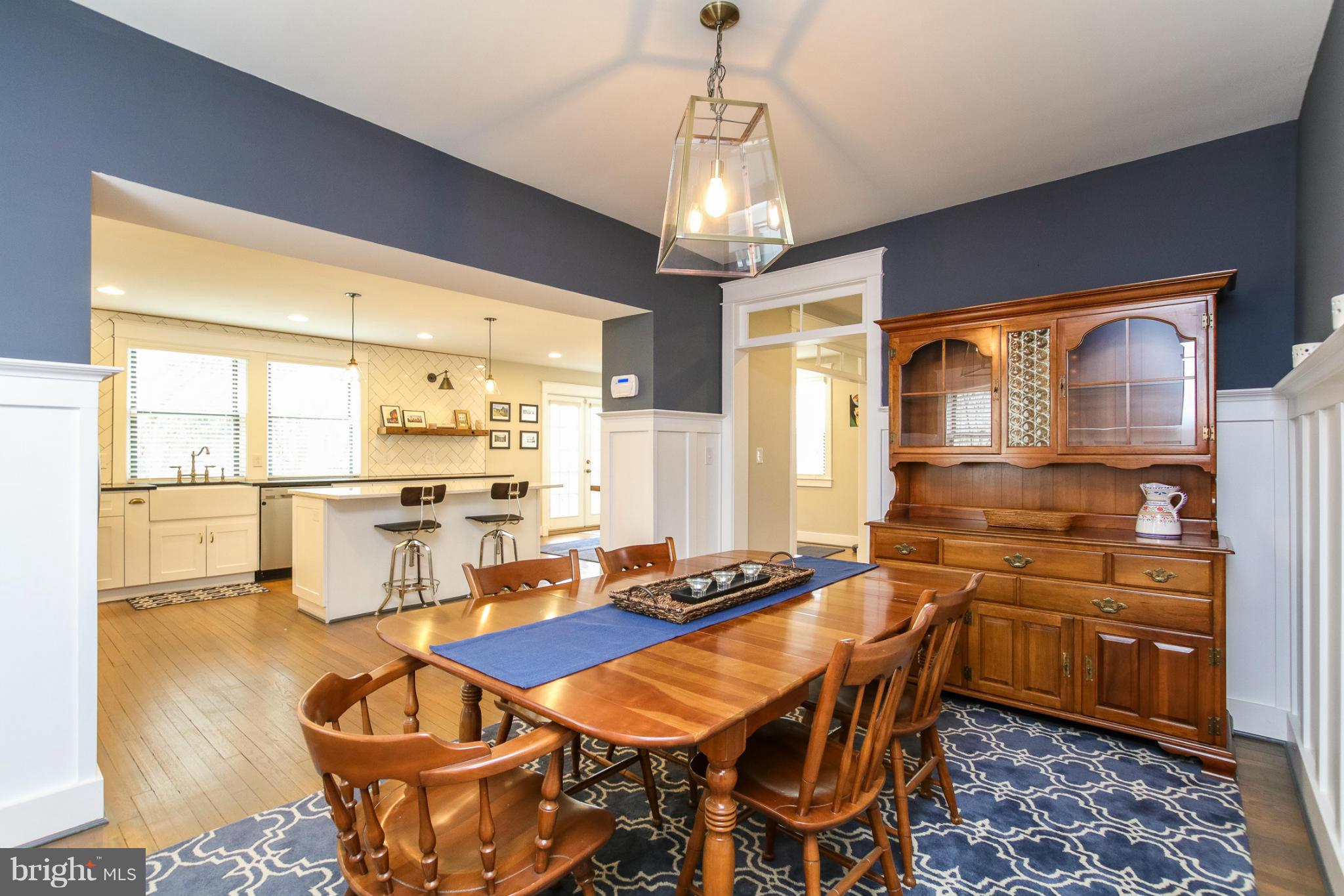 829 Kingston Road Baltimore, MD 21212 - Photo 10 of 30 a dining room with stainless steel appliances kitchen island granite countertop a table chairs and a chandelier
