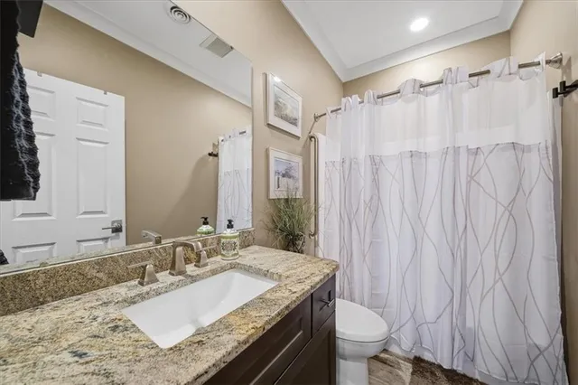 a bathroom with a granite countertop sink toilet and shower