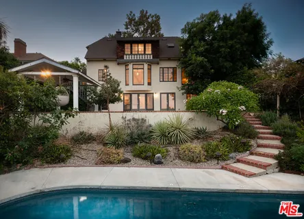 a front view of a house with a yard and potted plants