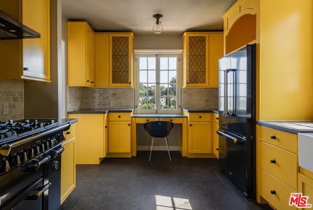 a kitchen with stainless steel appliances a stove a sink and white cabinets
