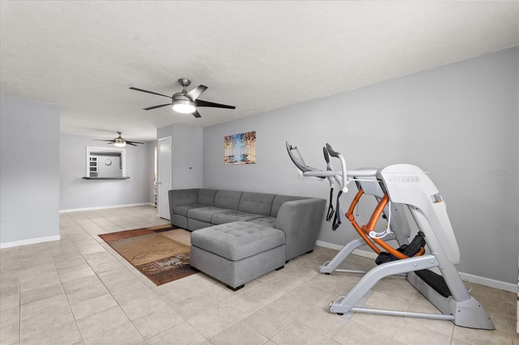 2500 Lee Road, Unit 208 Winter Park, FL 32789 - Photo 5 of 49 a living room with furniture a gym equipment and a chandelier