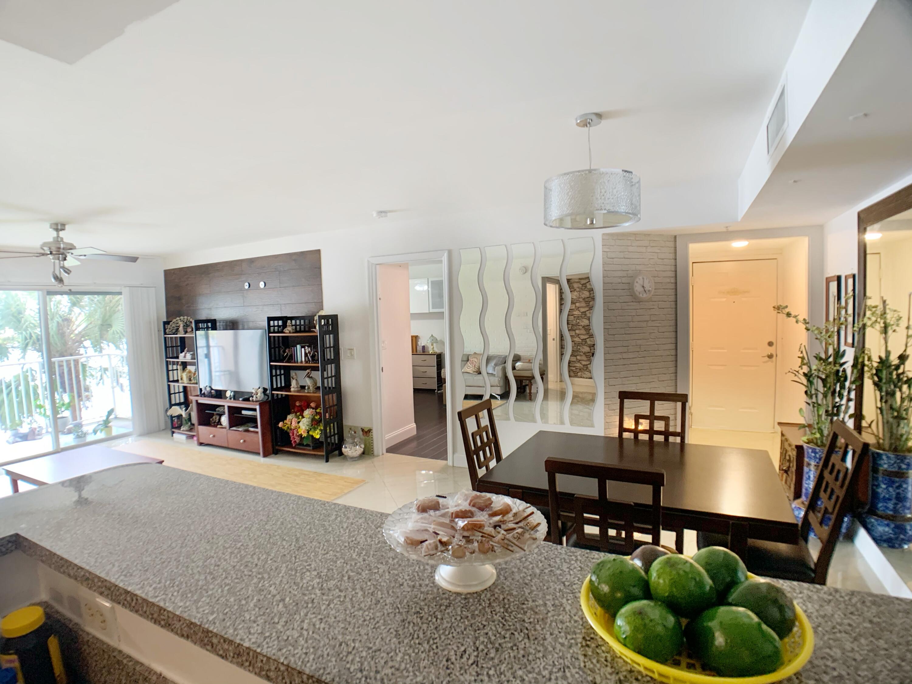 5015 Wiles Road, Unit 206 Coconut Creek, FL 33073 - Photo 14 of 32 a living room with furniture and floor to ceiling windows