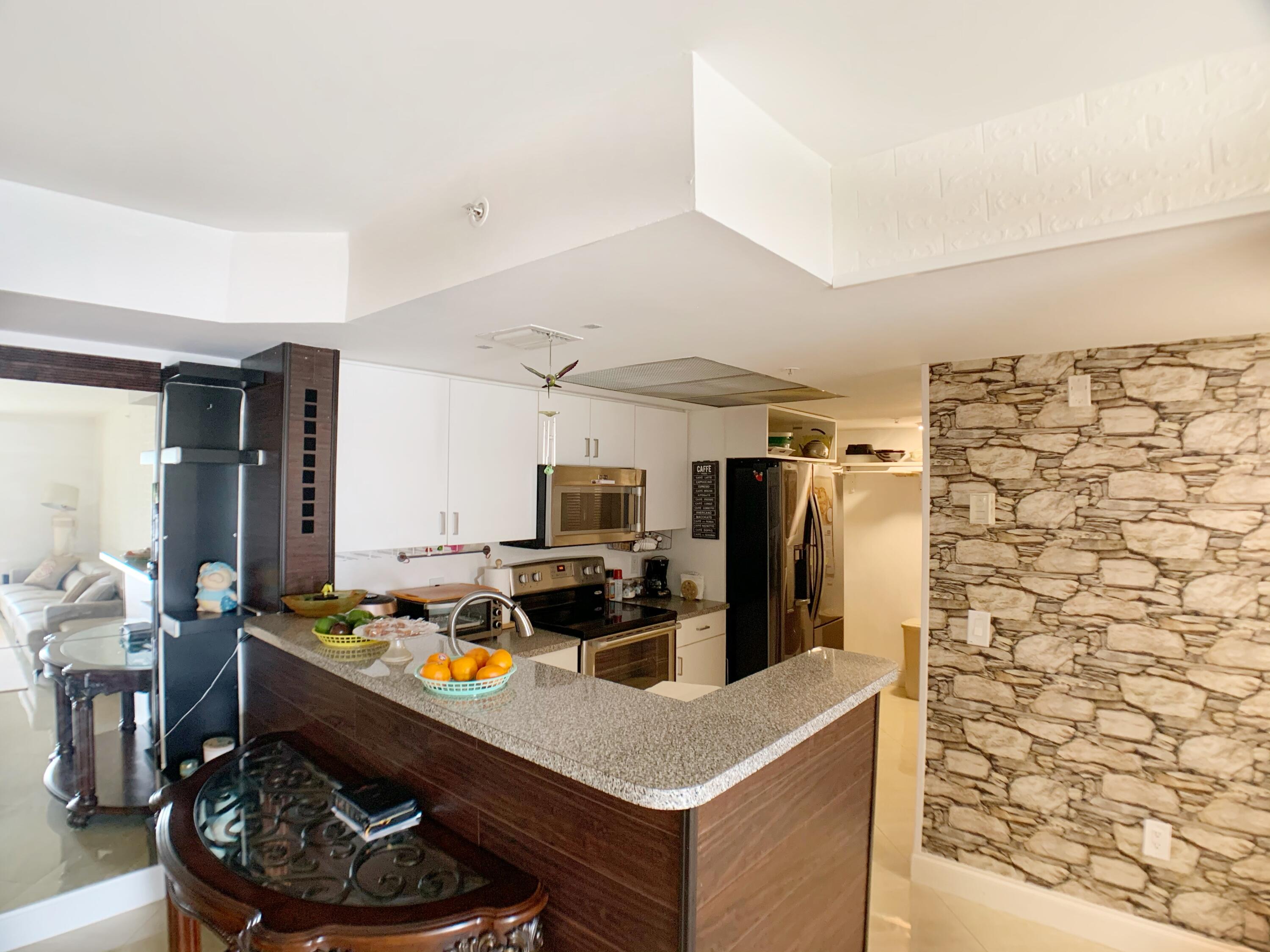 5015 Wiles Road, Unit 206 Coconut Creek, FL 33073 - Photo 16 of 32 a kitchen with stainless steel appliances a stove a refrigerator and a refrigerator