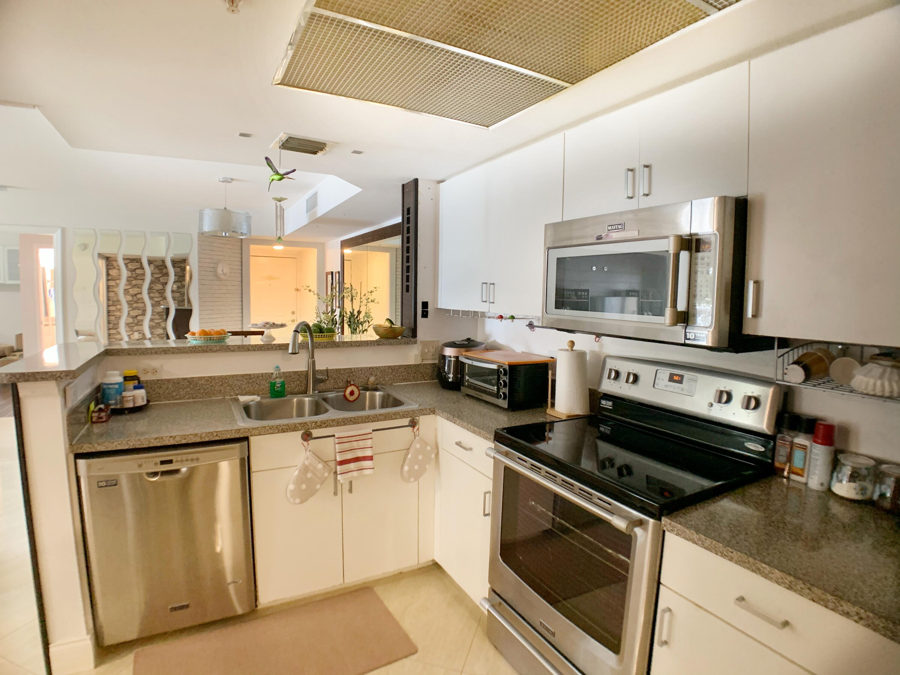 5015 Wiles Road, Unit 206 Coconut Creek, FL 33073 - Photo 17 of 32 a kitchen with a sink stove and microwave