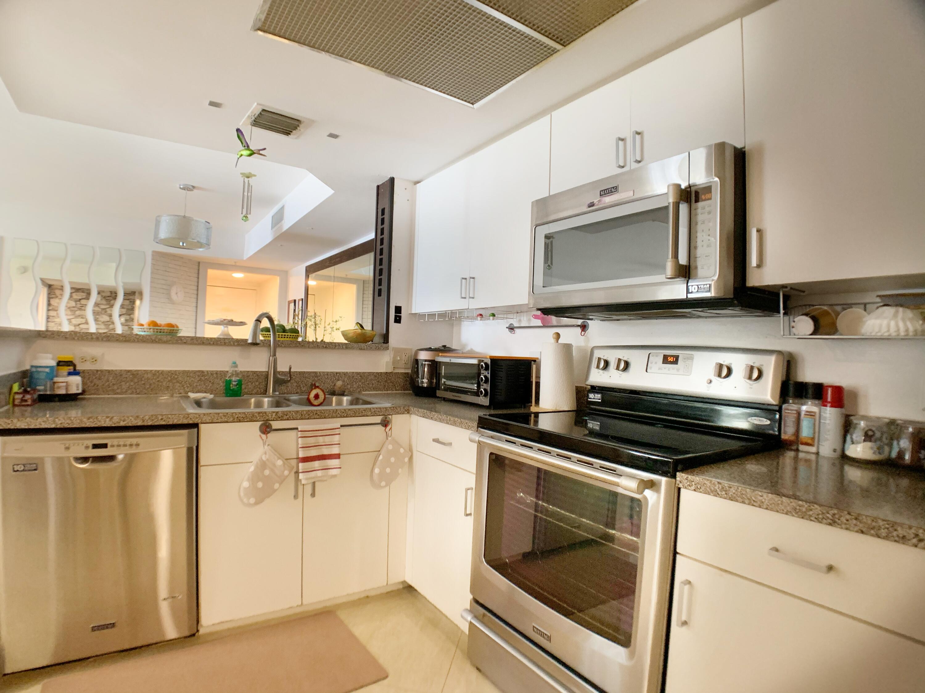 5015 Wiles Road, Unit 206 Coconut Creek, FL 33073 - Photo 18 of 32 a kitchen with cabinets stainless steel appliances and a sink