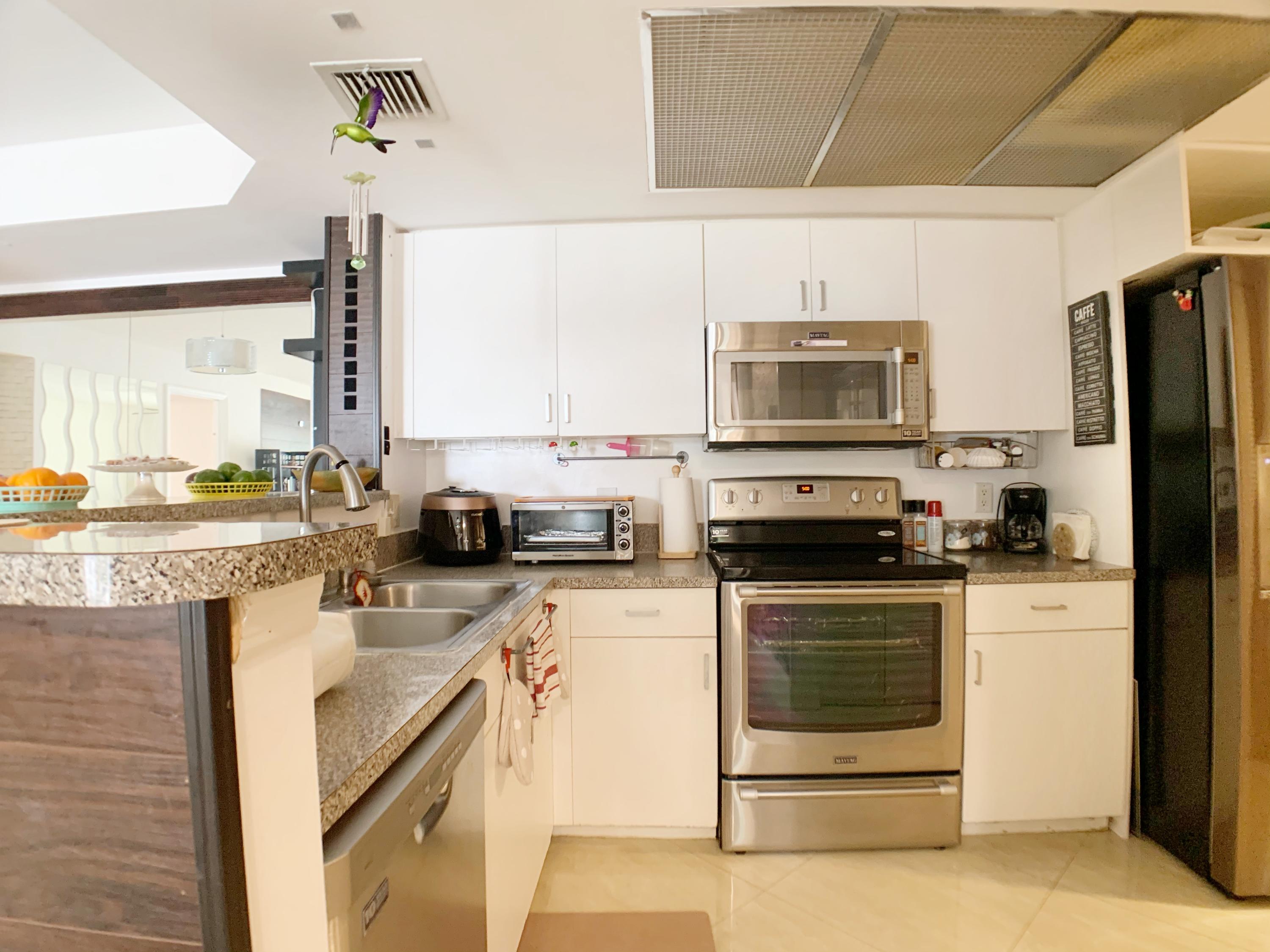 5015 Wiles Road, Unit 206 Coconut Creek, FL 33073 - Photo 20 of 32 a kitchen with a stove and a microwave