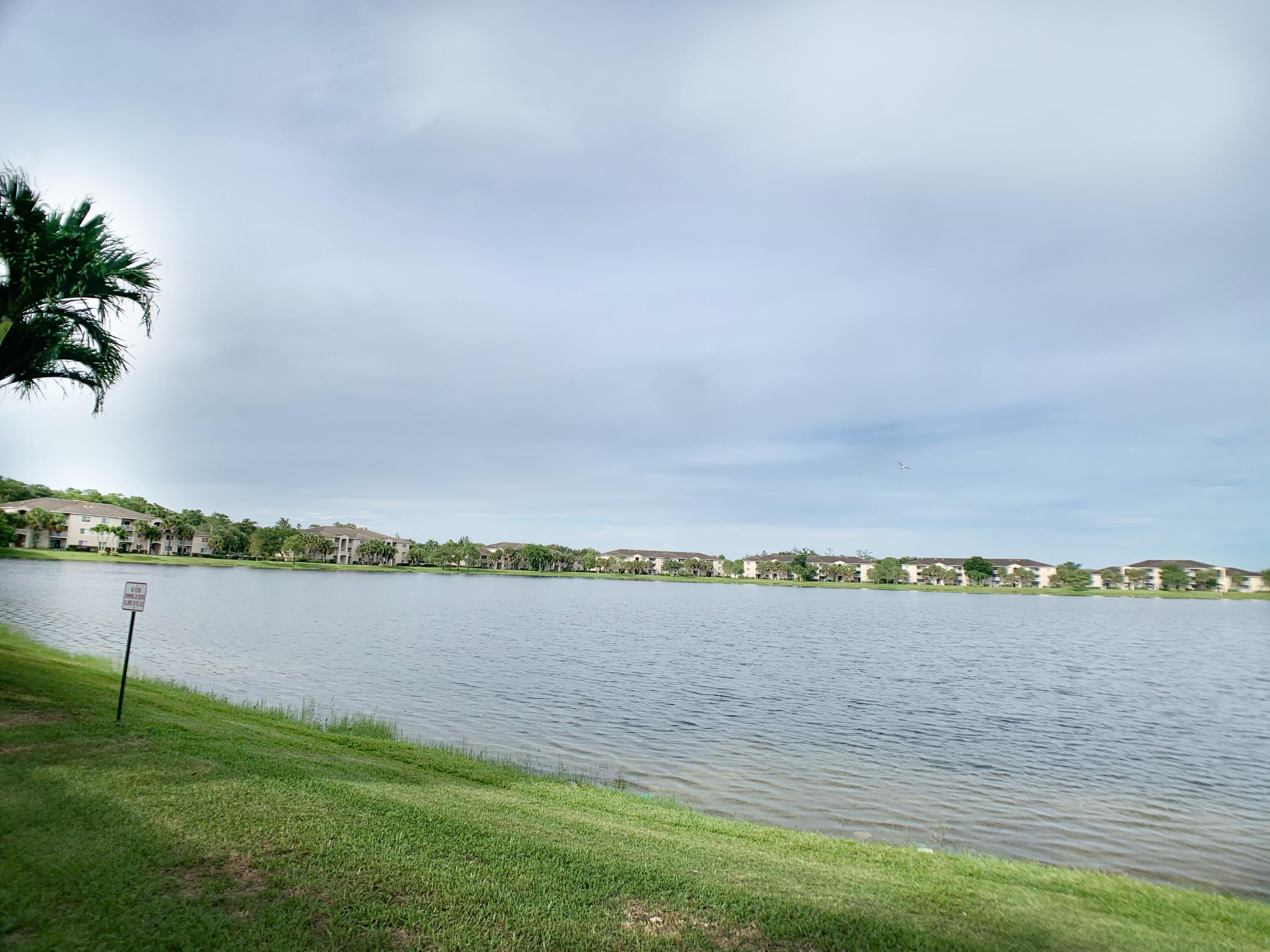 5015 Wiles Road, Unit 206 Coconut Creek, FL 33073 - Photo 2 of 32 a view of a lake with houses in the back